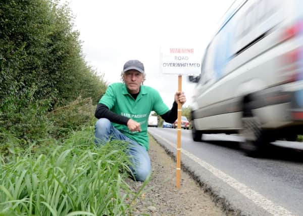Giles Binyon on Pagham Road with one an example of one of his survey signs. Photograph: Kate Shemilt/ ks180460-2