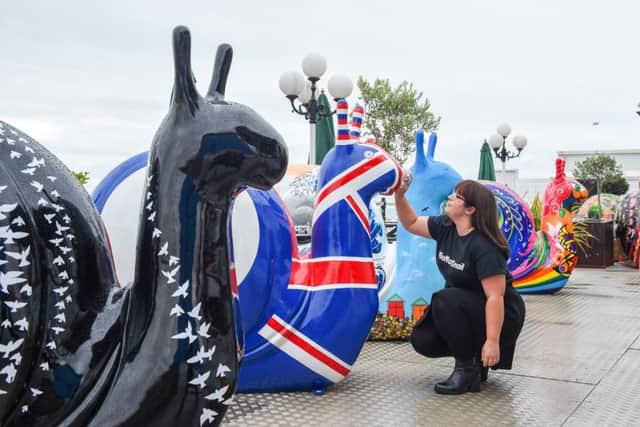 Kayla Fuller gives the snail sculptures a quick wipe at the launch of the Snailspace Art Trail on Brighton  Palace Pier (Photograph: Simon Dack/Vervate)