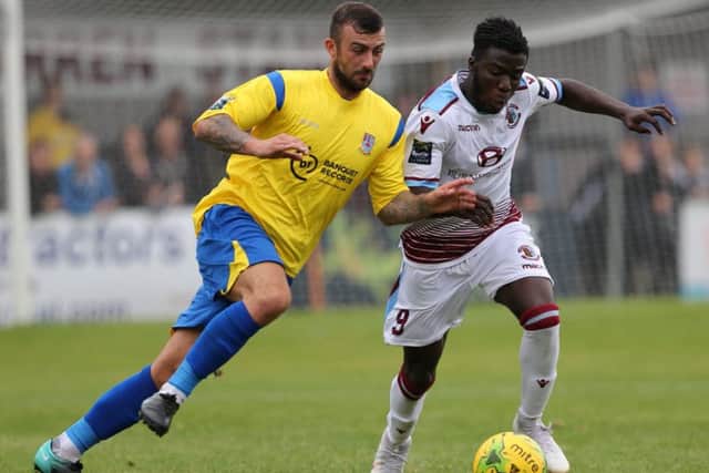 Daniel Ajakaiye tries to hold off a Kingstonian opponent. Picture courtesy Scott White