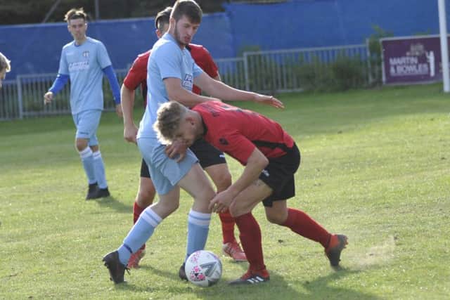 Rye Town midfielder Sammy Foulkes comes away with the ball.