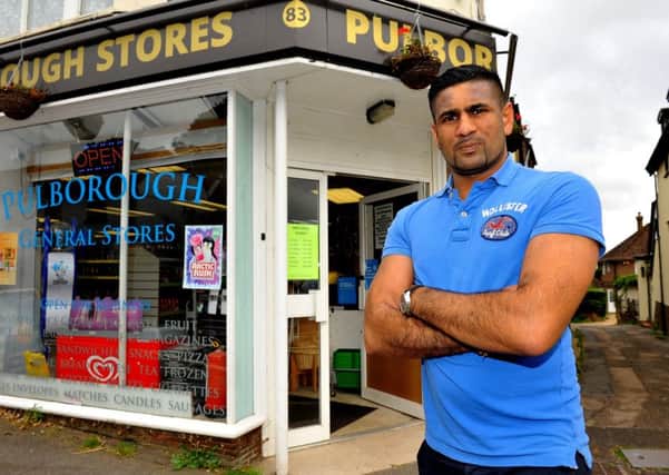 Break-in at Pulborough stores. Saagar Patel with the damaged shop door. Pic Steve Robards SR1824822 SUS-180919-122529001