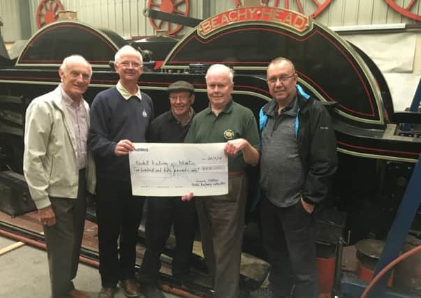 Sussex Vintage Model Railway representatives hand over their cheque to David Jones, (second from the right) project secretary and treasurer. 
From left to right they are Philip Cooke, Chairman, David Reed, Treasurer, member Tony Funnell who is also  working on the project, and Peter Bryant, Deputy Chairman. A 1930s Hornby loco stands on Beachy Heads running plate. SUS-180925-104646001
