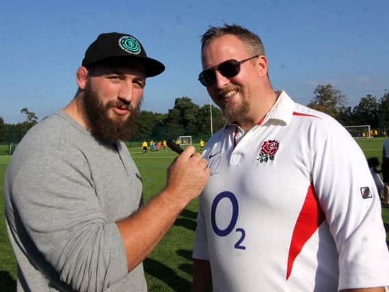 Joe Marler of England, and Harlequins captain sings his autograph on a fans England shirt. Picture by Ron Hill