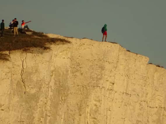Youth urinating off the cliffs at Seven Sisters. Photo by Wayne Spring / SWNS SUS-180927-110457001