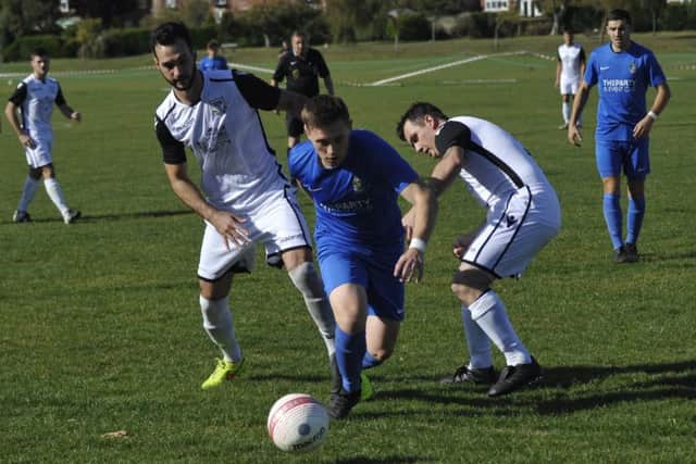 Jack McLean and Craig Ottley converge on a Selsey opponent.