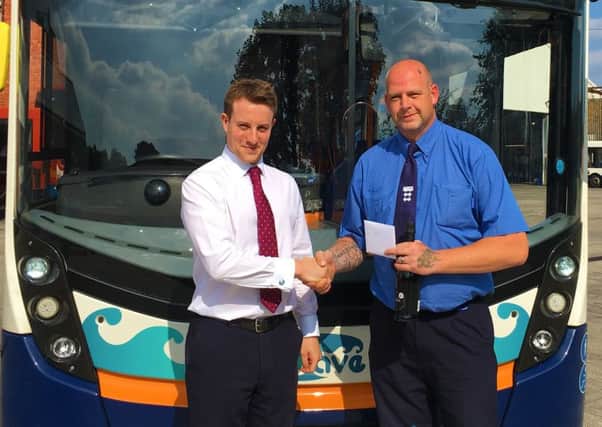 Graham Hall (right) receiving his prize from Hugh Loy (left) in front of a route 99 bus SUS-180110-135506001