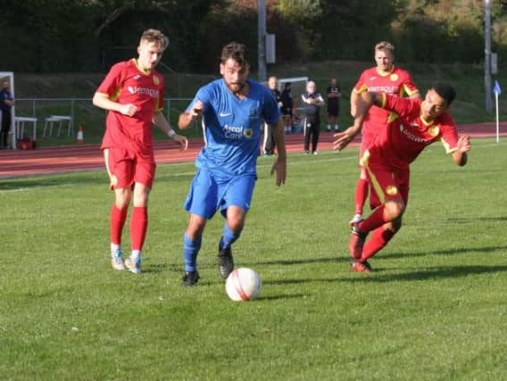 Dean Wright (blue) in action for Broadbridge Heath. Photo by Clive Turner