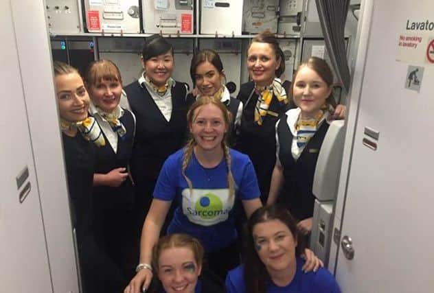 The three fundraisers with cabin crew on board the plane SUS-180810-111020001