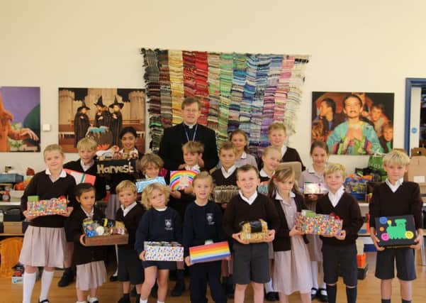 Rev Will Hughes and pupils at the school's recent Harvest Festival