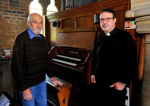 Churchwarden John Sired and Father Russell Stagg with the damaged organ