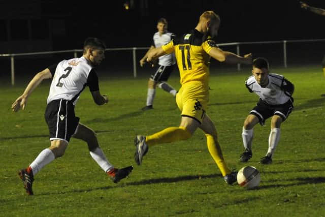 Bexhill United pair Connor Robertson (left) and Kyle Holden (right) keep a close eye on Heath wide player Max Miller