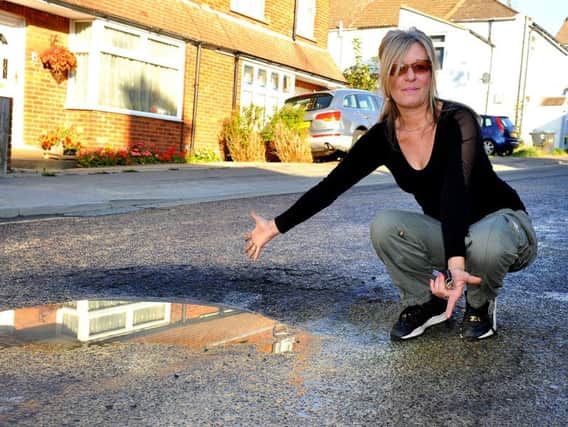 Liz Macphee next to the pot hole in Cyprus Road, Burgess Hill. Picture: Steve Robards