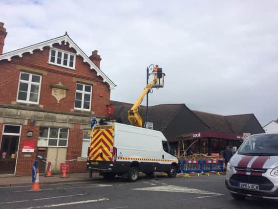 Fire and rescue workers remove the light from a lamppost next to Sainsbury's while clearing the area.