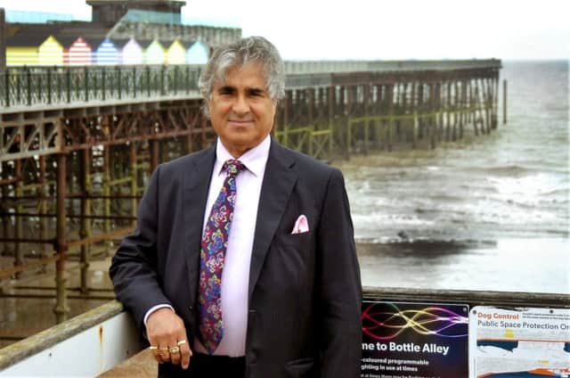 Sheikh Abid Gulzar pictured with Hastings Pier. Photo by Sid Saunders SUS-180619-165712001