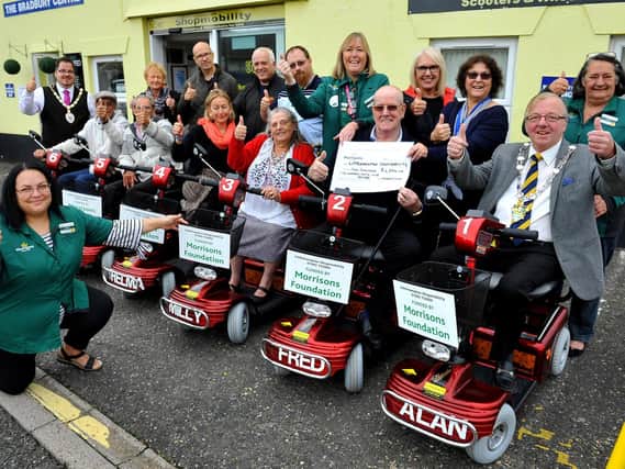Alison Whitburn, community champion at Morrisons Littlehampton , presents Littlehampton Shopmobility with a cheque for the six new mobility scooters. Picture: Steve Robards SR1827811
