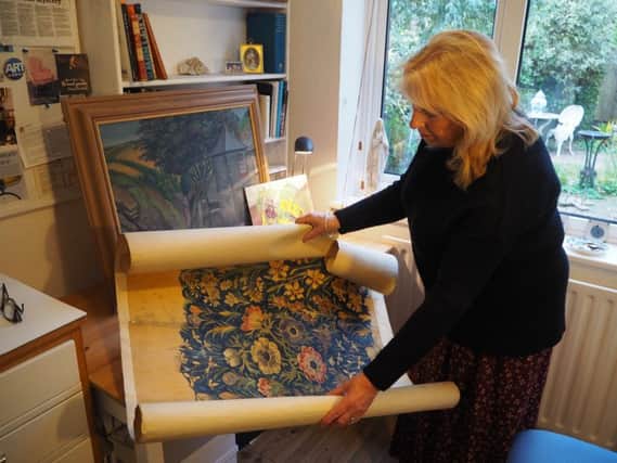 Jan Hodges holding a design for fabric from the Whaite archive