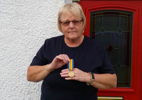 Wendy Singleton, 61, holding the World War One medal