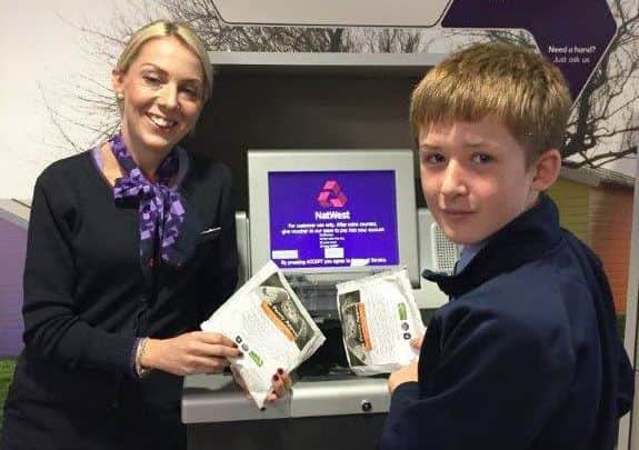 Alex Bailey counting the pennies at NatWest bank in Rustington