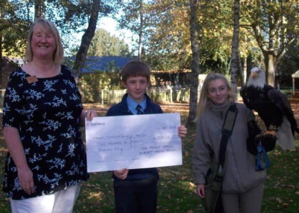Alex Bailey presents the cheque to Penny Smout, chief executive of The Hawk Conservancy Trust