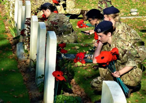 Cadets planting the poppies on gravestones at Western Road Cemetery in Haywards Heath