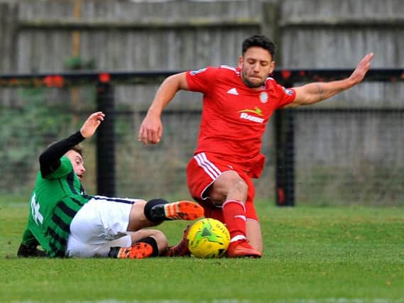 Worthing's Alex Parsons slides in to make a tackle during Saturday's match at Burgess Hill. Picture by Steve Robards