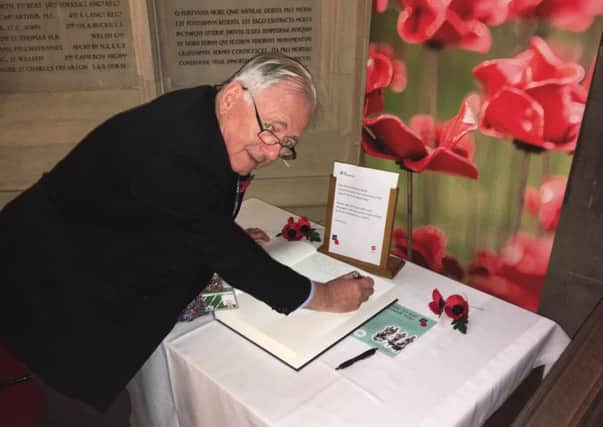 Sir Peter Bottomley signing the House of Commons Book of Remembrance SUS-181031-111350003