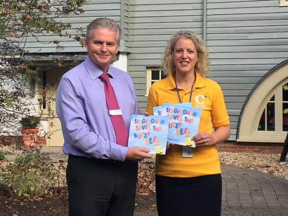 Rob Vince, operations manager, presents copies of Stagecoach Saves the Buzzy Bees to Alison Taylor, corporate fundraiser, at Chestnut Tree House children's hospice