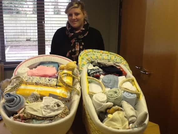 Michelle Earwaker, Hastings Baby Basics volunteer, with two Moses' baskets ready to go out to expectant mums.