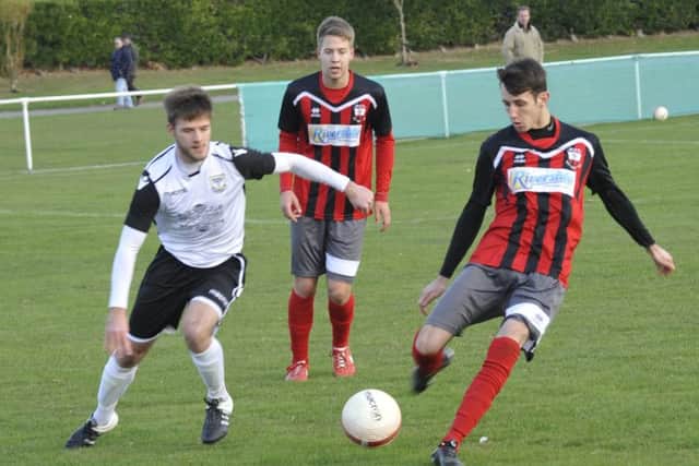 Bexhill United midfielder Sammy Bunn looks on as a Wick opponent clips the ball forward