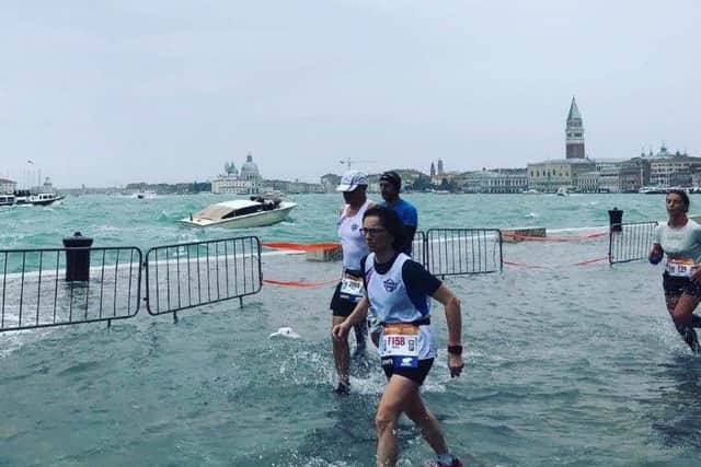 Runners running through the flooded streets in the Venice Marathon.