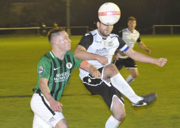 Bexhill United captain Craig McFarlane gets to the ball just before a Burgess Hill Town opponent. Pictures by Simon Newstead