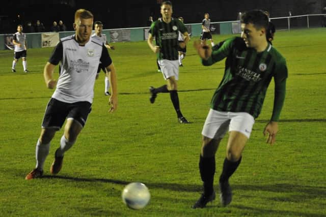 Bexhill United forward Zack McEniry closes down the Burgess Hill Town player in possession
