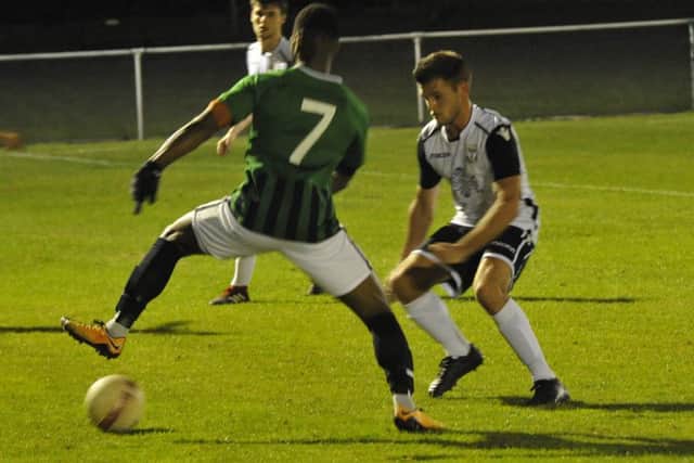 Bexhill United midfielder Jamie Bunn keeps a close eye on Burgess Hill Town winger Andre McCollin