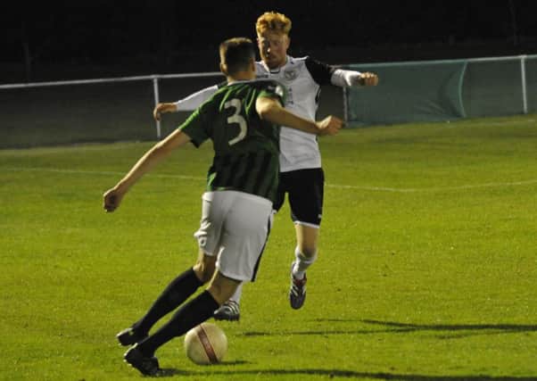Bexhill United midfielder Wayne Giles attempts to block the path of Burgess Hill Town's Sam Fisk. Pictures by Simon Newstead
