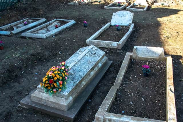 Flowers laid at the unearthed graves in the Brookside Avenue Industrial Estate graveyard in Rustington