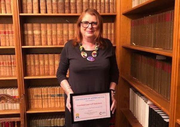 Christine Haniver, Partner at Cornfield Law, with our gold certificate in recognition of facilitating an amazing ?4.2million in legacy income for Cancer Research UK. SUS-181113-113223001