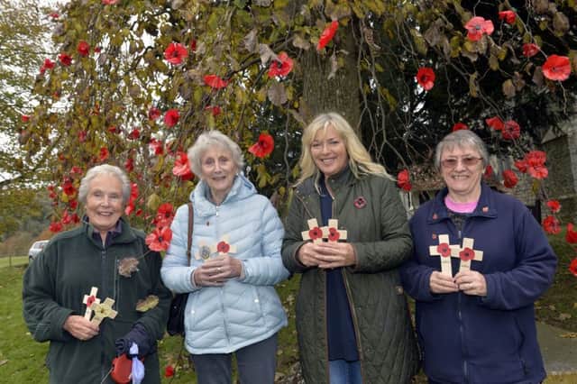 Valerie Arno, June Hogg, Amanda Kirkman and Jenny Wootton next to the 100 year old tree decorated with 500 poppies at St Andrews Church, Jevington Photo by Jon Rigby)