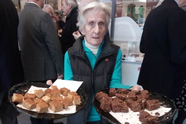 Arundel Museum life president Pauline Carder offering trench cake made from the original government recipe, right, and gingerbread made from Alice Officers hand-written 1917 recipe. She explained trench cake was created to provide carbohydrates for the soldiers, who were eating too much protein as their diet consisted mainly of bully beef.