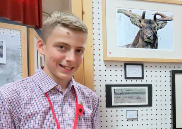 Louis Dunstan, the club's youngest member,with the framed photo he sold at the exhibition