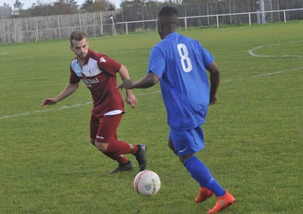 Little Common full-back Jordan Harris keeps a close eye on Shoreham wide player Martin Mutungi. Pictures by Simon Newstead