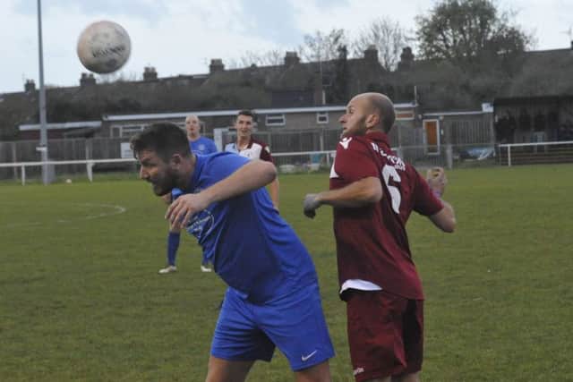 Little Common player-manager Russell Eldridge contests an aerial ball with two-goal Shoreham forward Ryan McBride