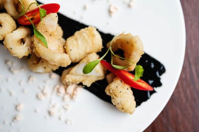 Salt and pepper calamare and black garlic. Photo by XDB Photography.