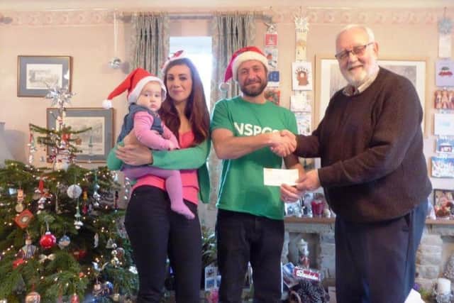 Sam Cocozza presenting a cheque to NSPCC South and Mid Sussex branch treasurer Peter Bowers, with his partner May and daughter Emmie