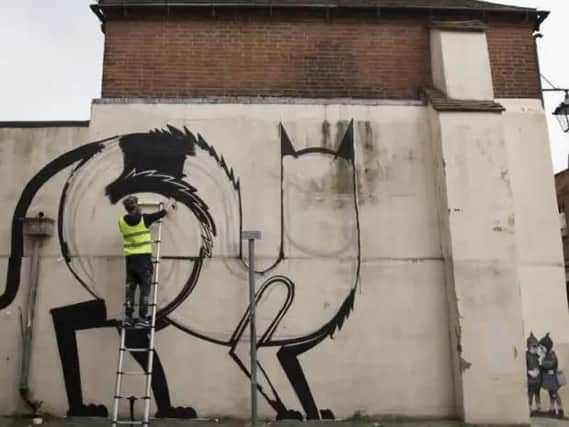 Belgian artist Joachim at work painting King of Cats in North Pallant