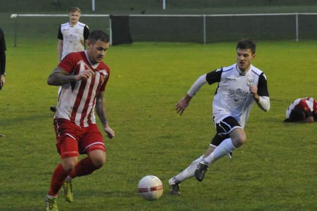Bexhill United midfielder Sammy Bunn keeps a close eye on the Steyning player in possession