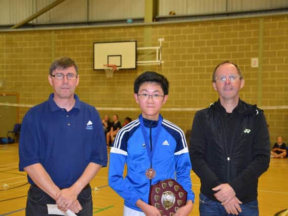 Henry Wong being presented with the under 16 singles award by Sussex County Badminton Chairman Mark Russ and Tournament Official Neil Warwick.