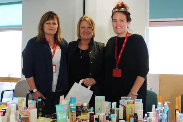 Legal & General Mature Savings employees holding fundraising make-up stall at St Barnabas House