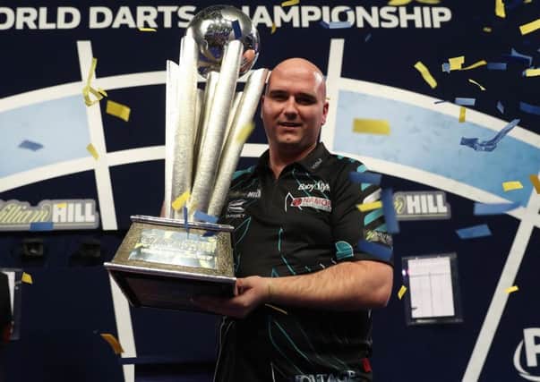 Rob Cross clutches the William Hill World Darts Championship trophy after defeating Phil Taylor in last year's final. Picture courtesy Lawrence Lustig/PDC