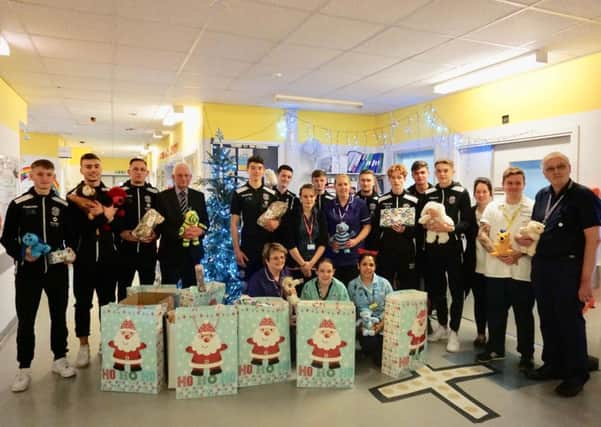 Hastings United Football Club players and staff with staff from the Kipling Ward at The Conquest Hospital