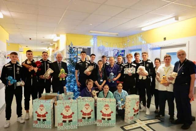 Hastings United Football Club players and staff with staff from the Kipling Ward at The Conquest Hospital